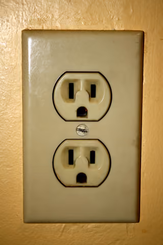 Exterior face of a grounded US household electrical outlet